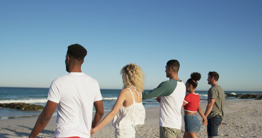 Diverse Friends Holding Hands Facing Ocean Horizon on Sunny Beach - Free Images, Stock Photos and Pictures on Pikwizard.com