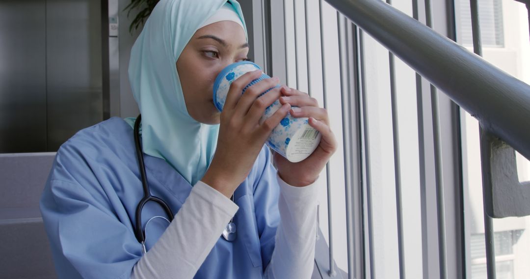 Female Nurse in Hijab Drinking Coffee During Break in Hospital - Free Images, Stock Photos and Pictures on Pikwizard.com