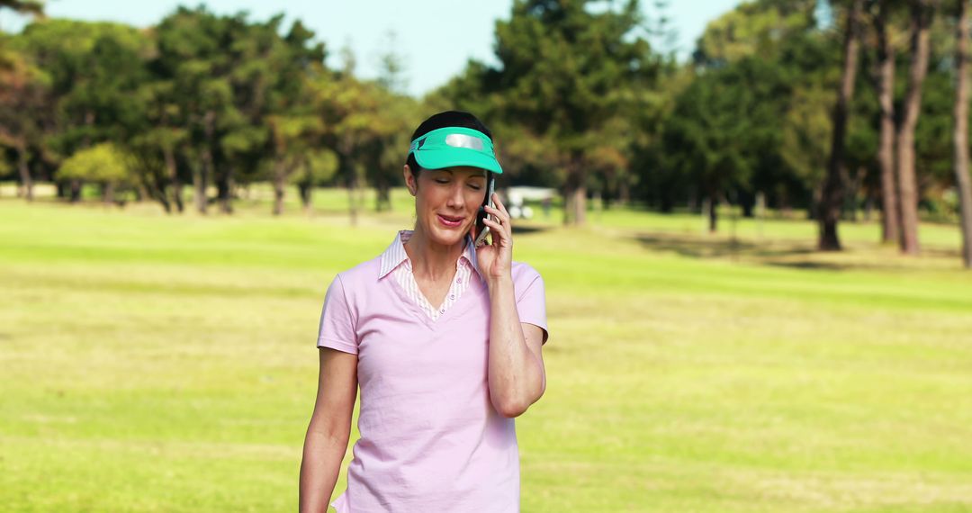 Woman Talking on Phone While Walking in Park on Sunny Day - Free Images, Stock Photos and Pictures on Pikwizard.com