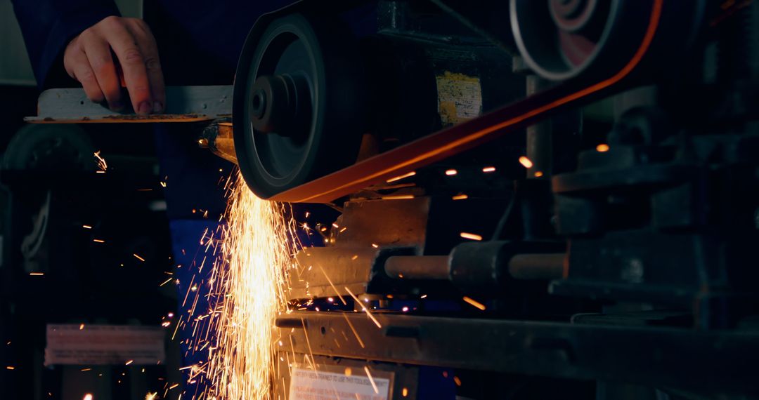 A worker operates a grinding machine, creating a spark shower - Free Images, Stock Photos and Pictures on Pikwizard.com