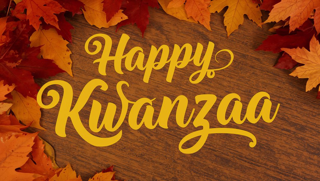 Happy Kwanzaa Hand-Lettered Gold Script on Wooden Tabletop with Autumn Leaves