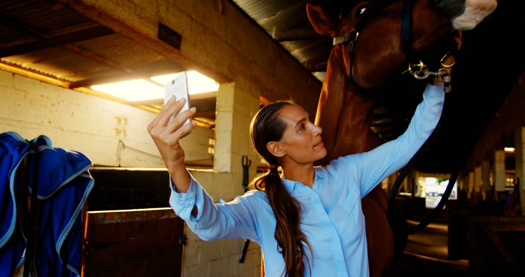 Woman taking selfie with horse in stable during sunset - Free Images, Stock Photos and Pictures on Pikwizard.com