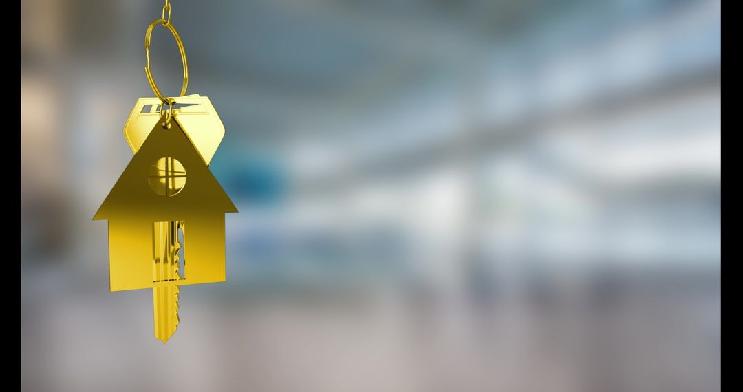 Golden House Key Hanging Against Blurry Background