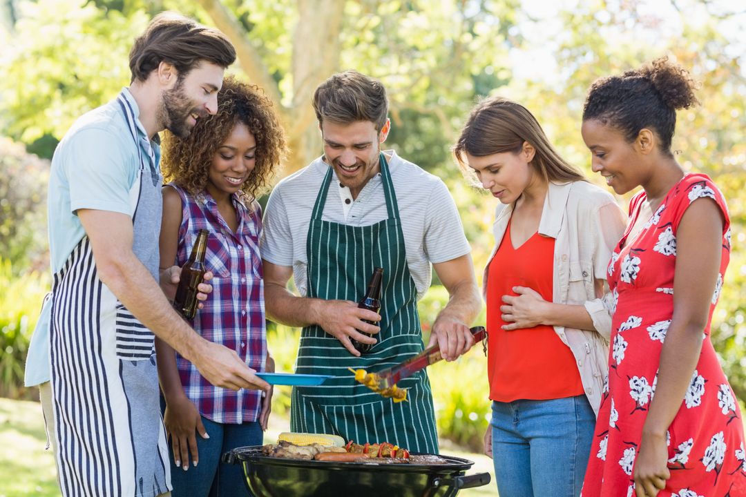 Happy Friends Grilling Together in Park on Sunny Day - Free Images, Stock Photos and Pictures on Pikwizard.com