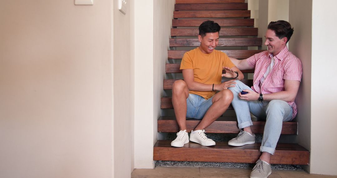 Diverse Couple Laughing Together on Stairs at Home