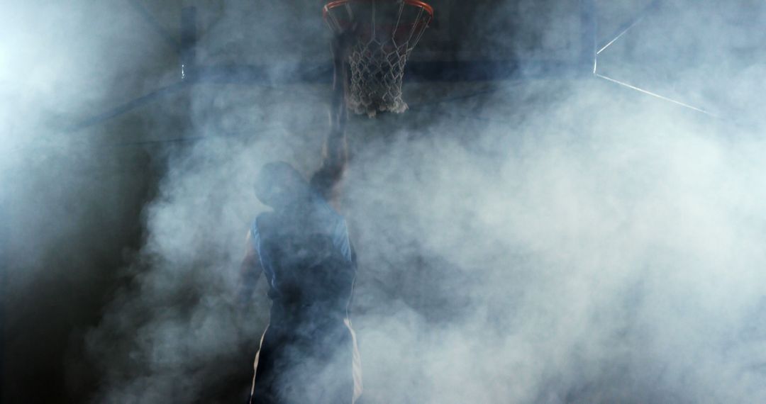 Basketball Player Jumping for Dunk in Smoky Gym - Free Images, Stock Photos and Pictures on Pikwizard.com