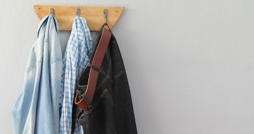 Clothes Hanging on Wooden Coat Rack Against Gray Wall - Free Images, Stock Photos and Pictures on Pikwizard.com