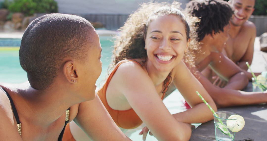 Friends Enjoying Poolside Laughter with Refreshing Drinks