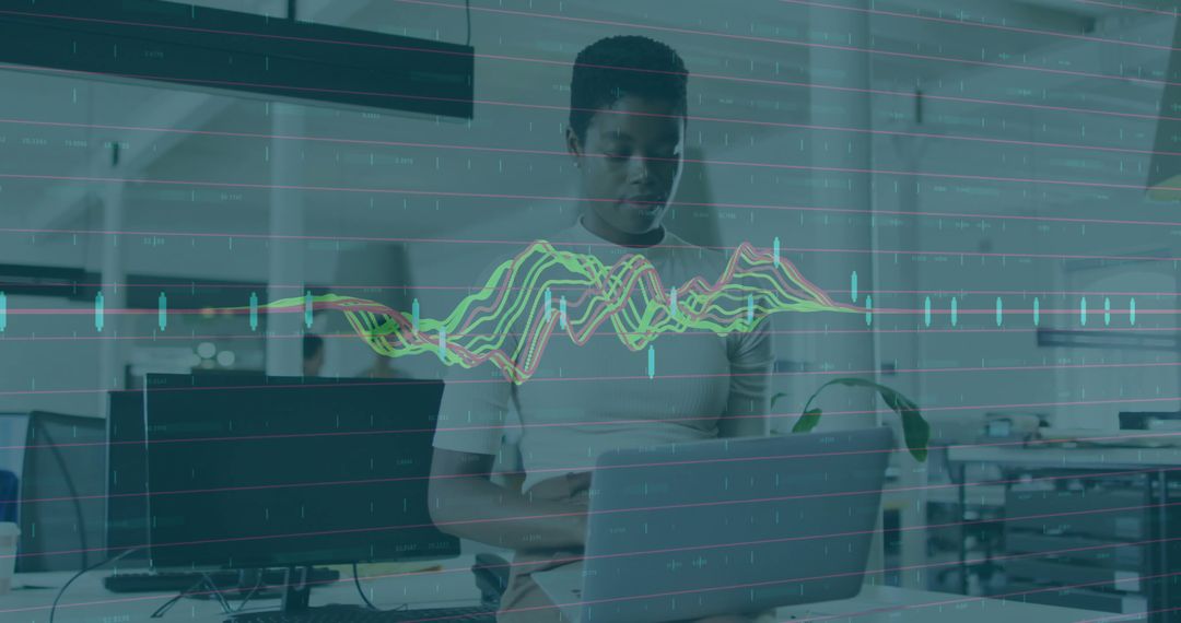 Typing on laptop with neon data waveform overlay visualizing analytics in open office