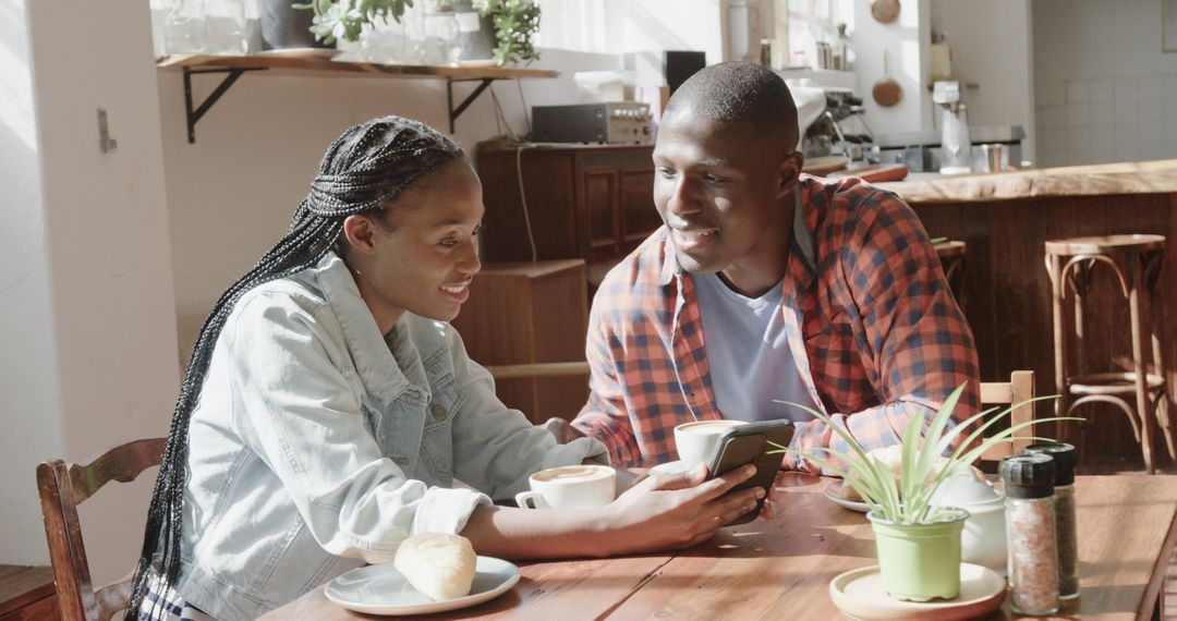 Happy Couple Enjoying Coffee and Technology Moment in Café