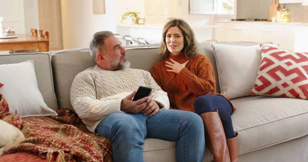 Couple Sitting on Sofa in Cozy Open-Plan Home Sharing Conversation and Relaxation