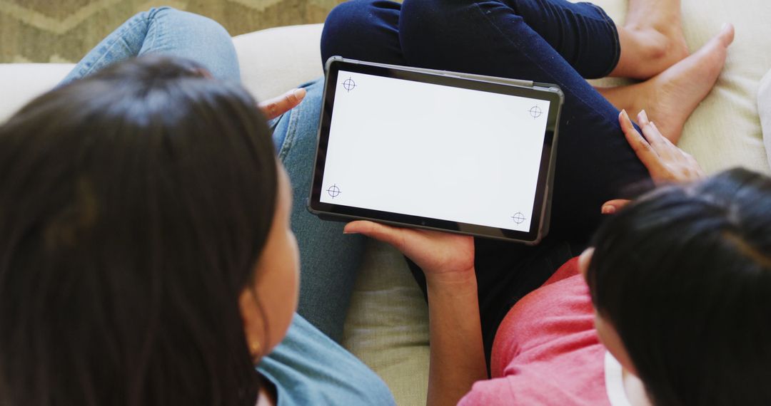 Two People Sharing a Blank Tablet Screen While Sitting on a Couch - Free Images, Stock Photos and Pictures on Pikwizard.com