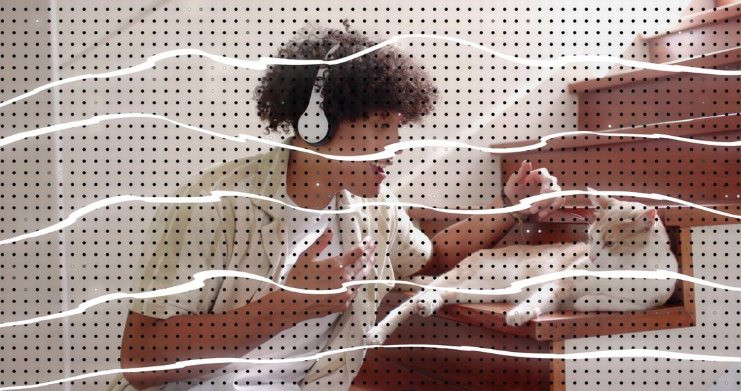 Curly-haired man wearing headphones petting cat in open drawer with halftone dot overlay