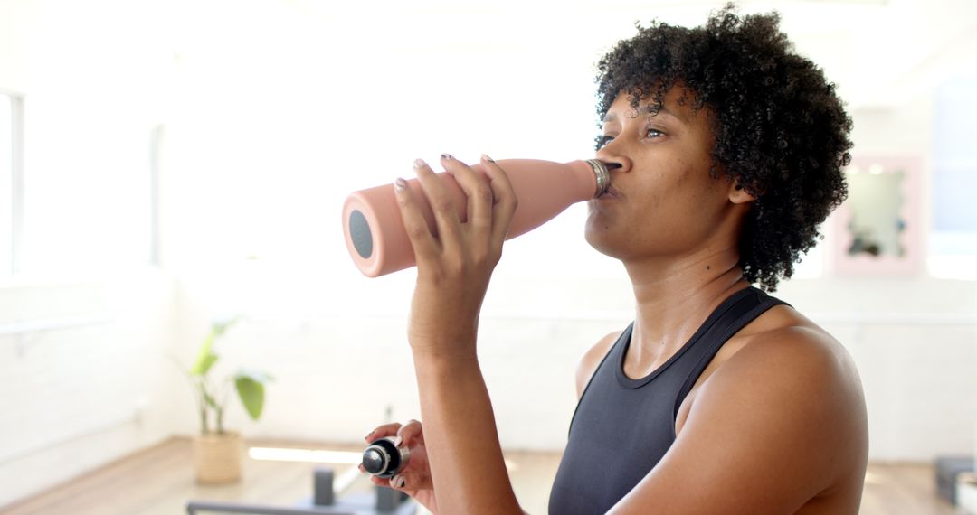 Yoga Instructor Refreshing with Bottle During Workout Session