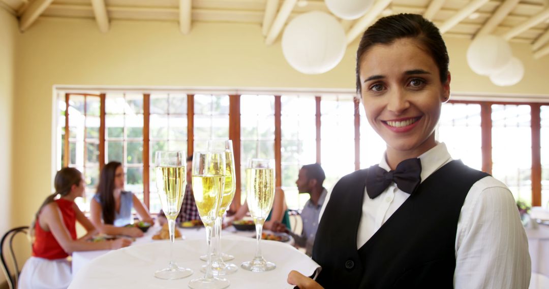 Smiling Waitress in Uniform Serving Champagne at Restaurant - Free Images, Stock Photos and Pictures on Pikwizard.com