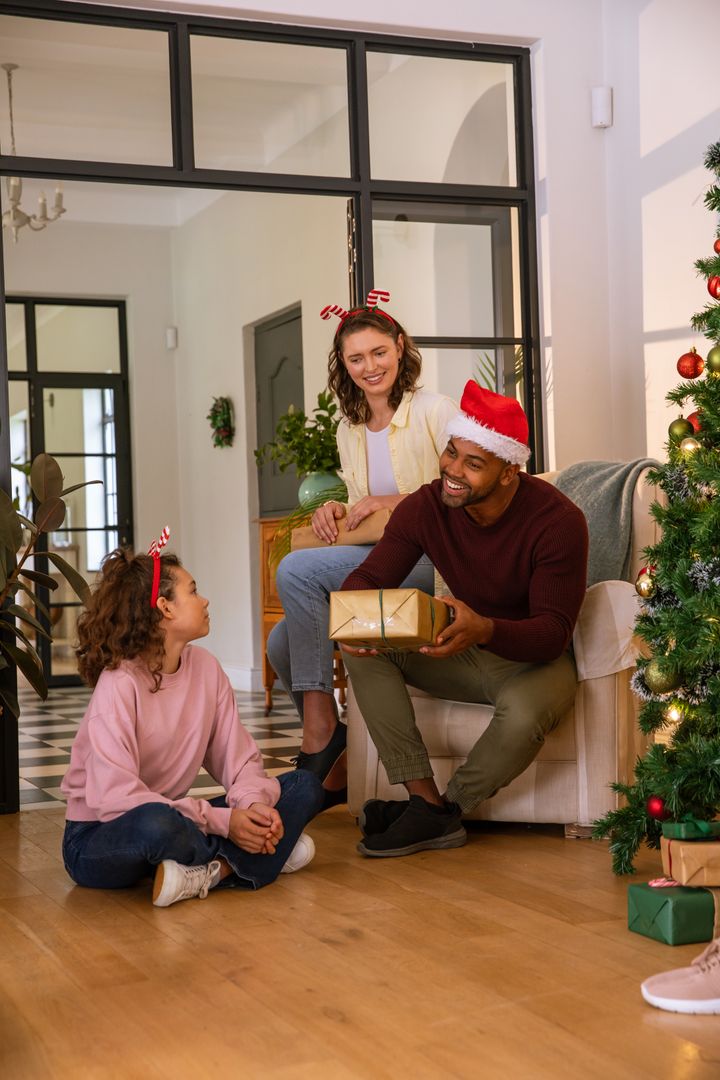 Joyful Family Exchanging Gifts by Christmas Tree in Festive Setting
