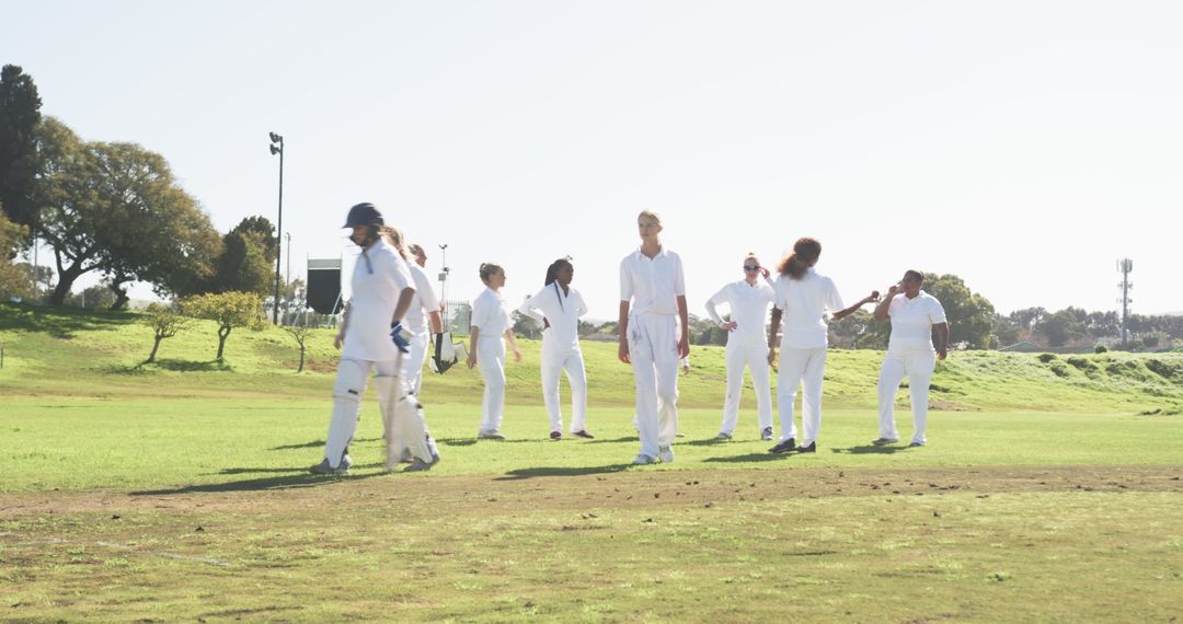 Diverse Female Cricket Team Conversing on Sunny Field