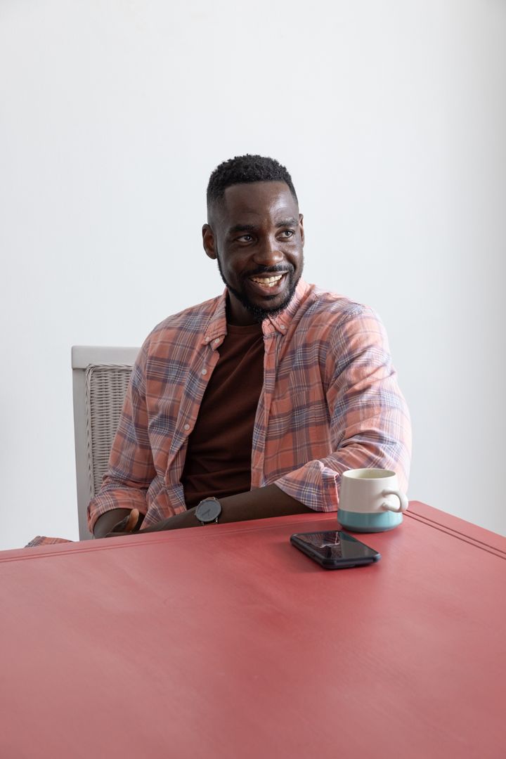 African American Man Smiling at Workplace with Coffee Mug