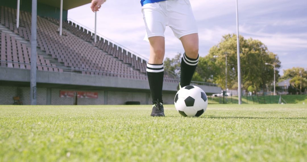 A soccer player prepares to kick a ball on a lush green field, with copy space - Free Images, Stock Photos and Pictures on Pikwizard.com