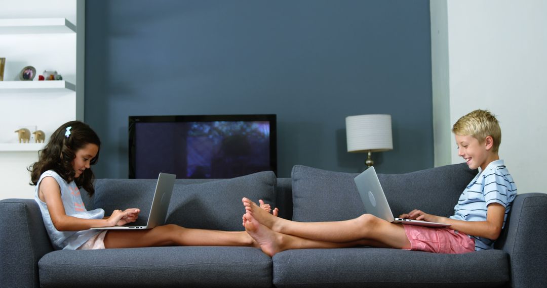 Children Relaxing on Sofa Using Laptops - Free Images, Stock Photos and Pictures on Pikwizard.com