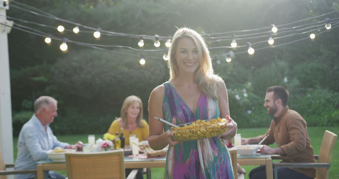 Smiling Woman Serving Food at Outdoor Family Gathering - Free Images, Stock Photos and Pictures on Pikwizard.com