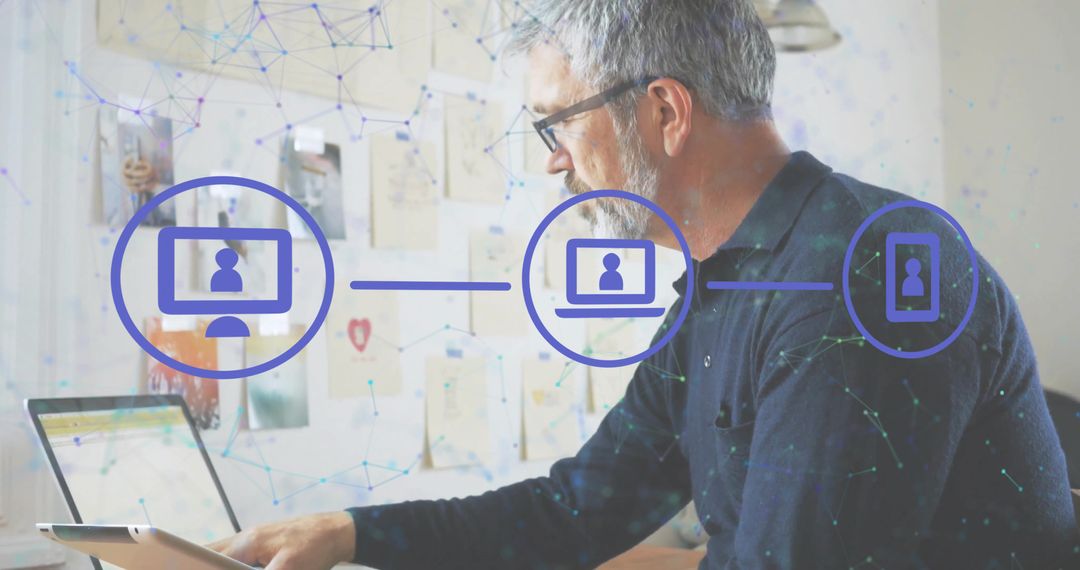 Senior professional working remotely with laptop and tablet network connectivity overlay