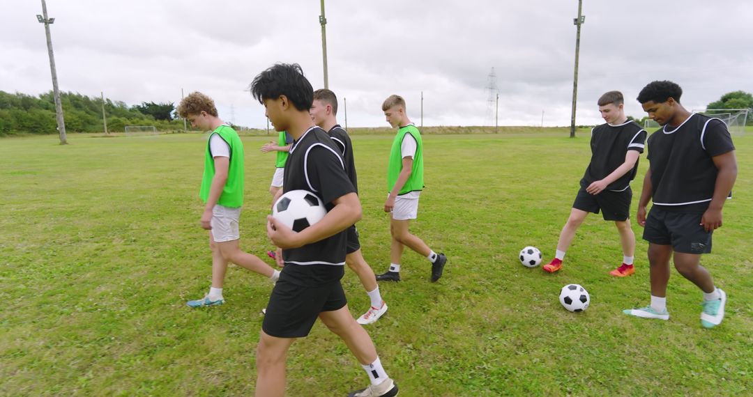 Diverse Teenage Boys at Soccer Practice with Mesh Bibs and Soccer Balls