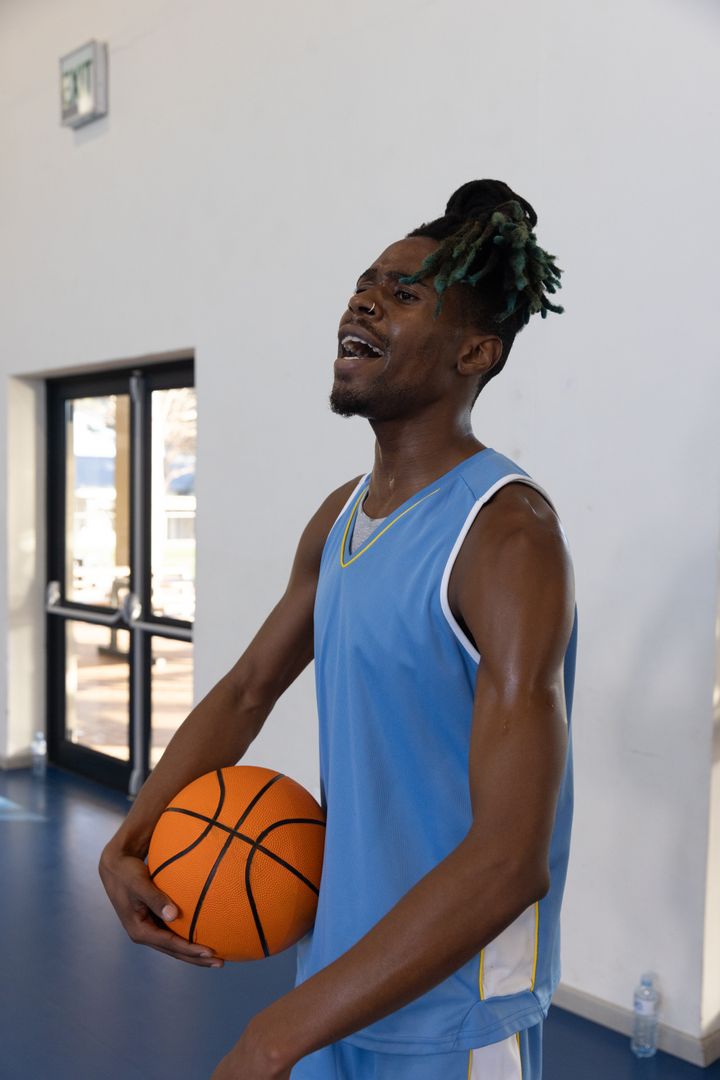 Basketball Athlete Holding Ball and Sweating After Intense Practice