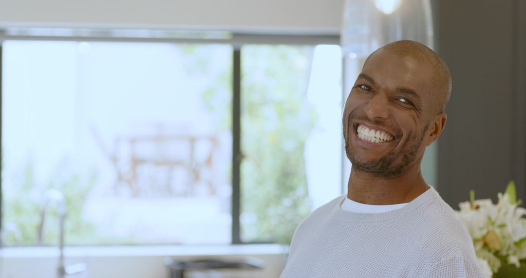 Smiling Man Enjoying Kitchen Environment with Bright Natural Light