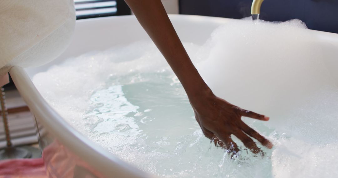 Woman Testing Water Temperature in Bathtub with Bubbles - Free Images, Stock Photos and Pictures on Pikwizard.com