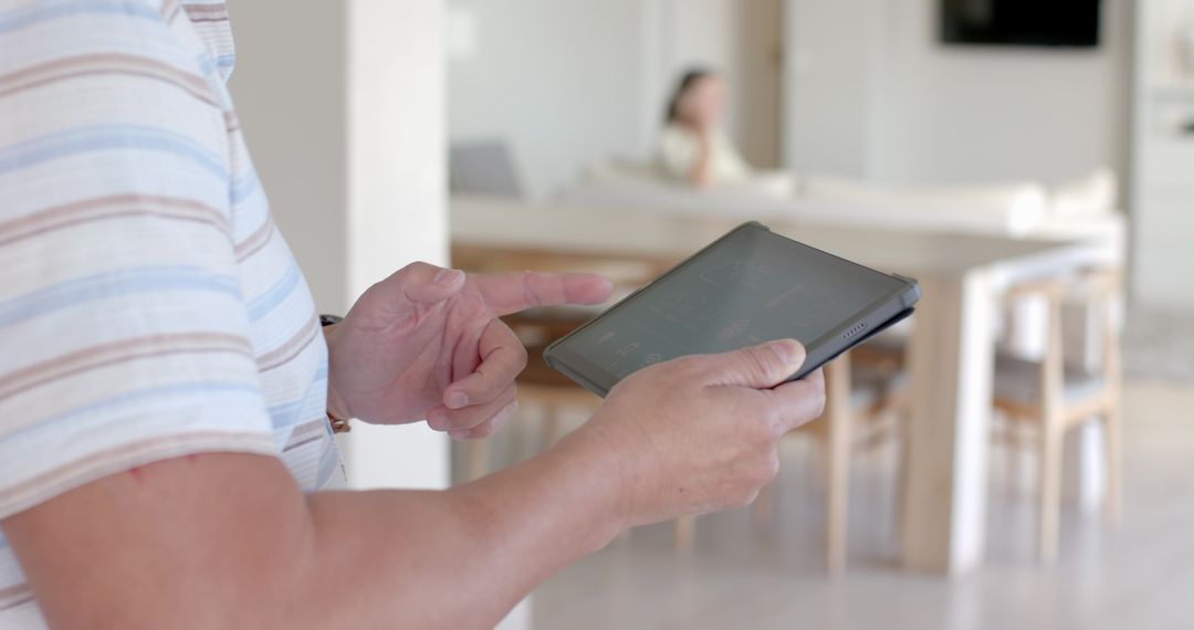 Middle-aged Man Engaging with Tablet Device in Elegant Home Interior