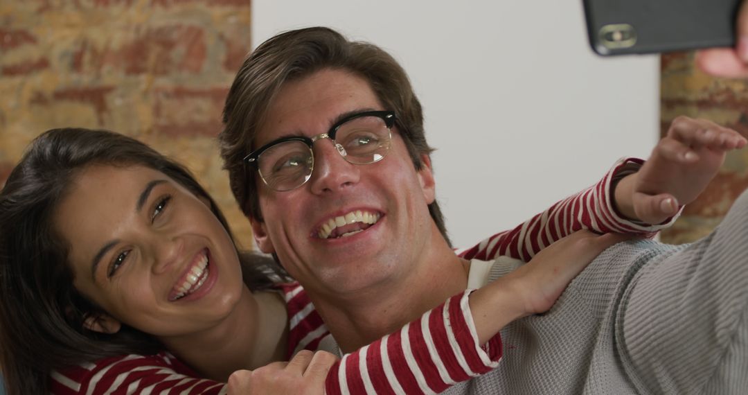 Joyful couple capturing memories with smartphone selfie