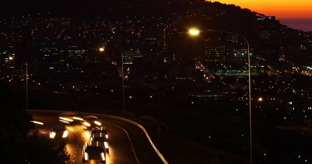 City Traffic on Winding Road at Sunset with City Lights in Background - Free Images, Stock Photos and Pictures on Pikwizard.com