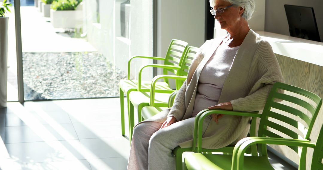 A senior Caucasian woman sits patiently in a waiting area, in a medical facility, with copy space - Free Images, Stock Photos and Pictures on Pikwizard.com