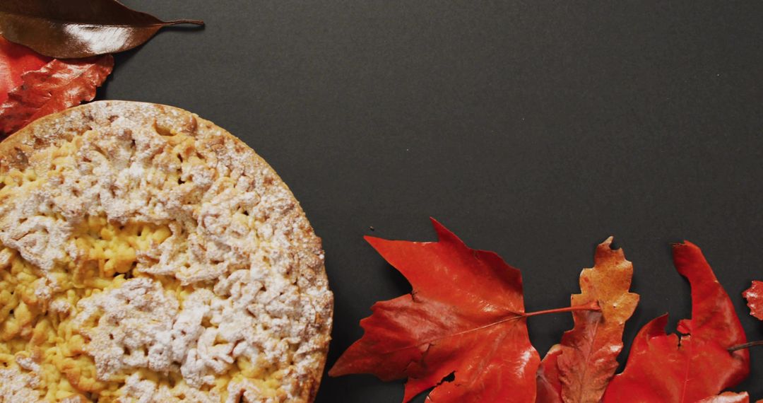 Showcasing Autumn Crumble Pie Dusting Powdered Sugar on Charcoal Background with Red Orange Leaves