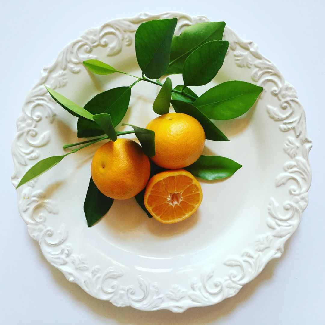 Fresh Oranges and Leaves on Decorative Plate - Free Images, Stock Photos and Pictures on Pikwizard.com