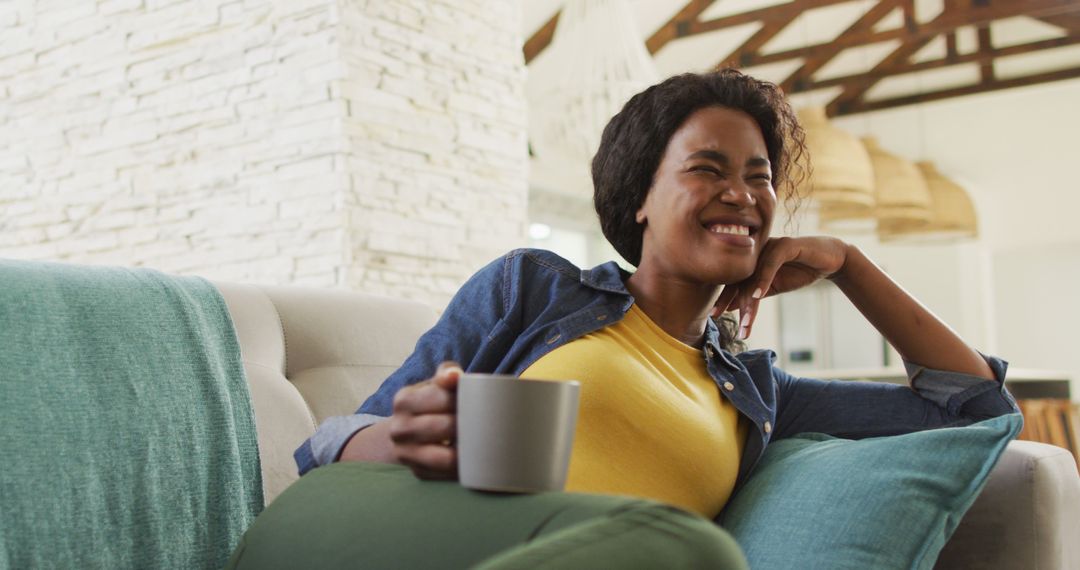 Smiling Woman Relaxing on Couch with Coffee Mug - Free Images, Stock Photos and Pictures on Pikwizard.com