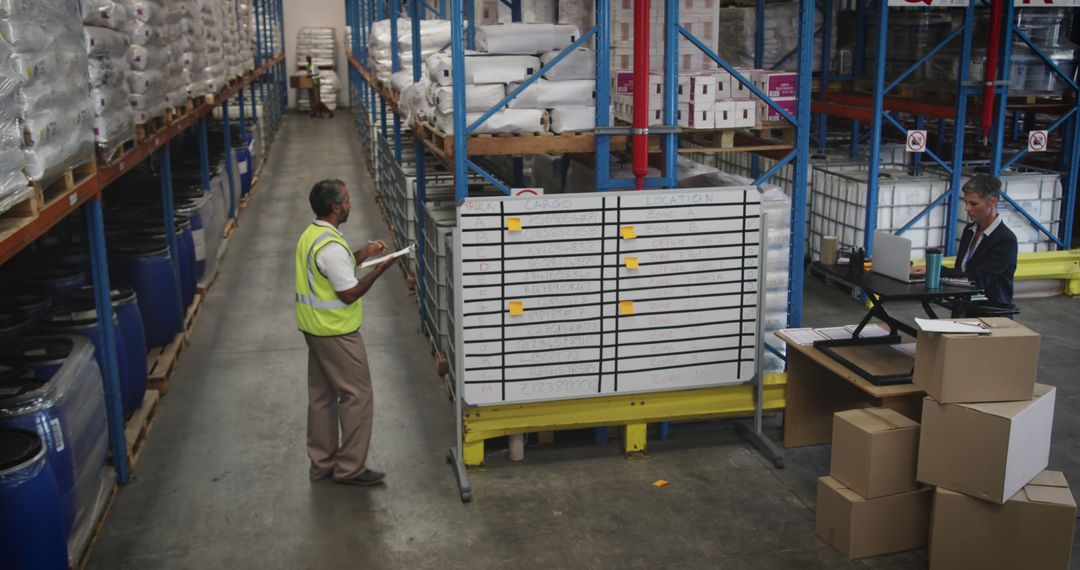 Warehouse Workers Managing Inventory on Whiteboard - Free Images, Stock Photos and Pictures on Pikwizard.com