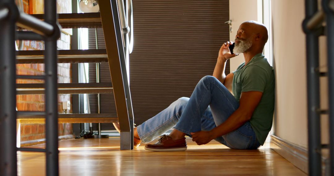 Pensive Man Sitting on Floor Making Phone Call - Free Images, Stock Photos and Pictures on Pikwizard.com