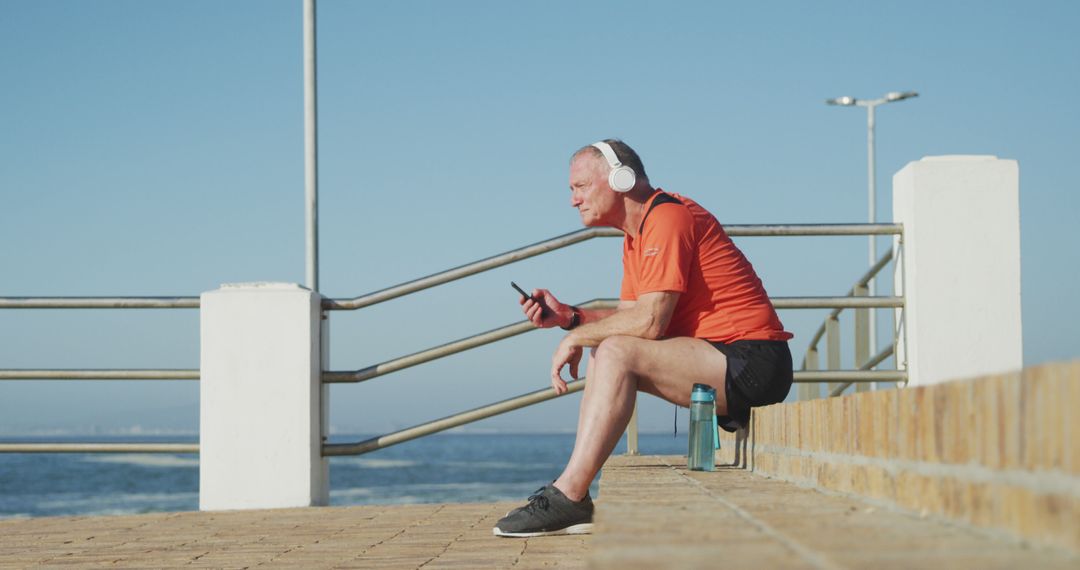 Middle-Aged Man Relaxing by Seaside with Headphones - Free Images, Stock Photos and Pictures on Pikwizard.com