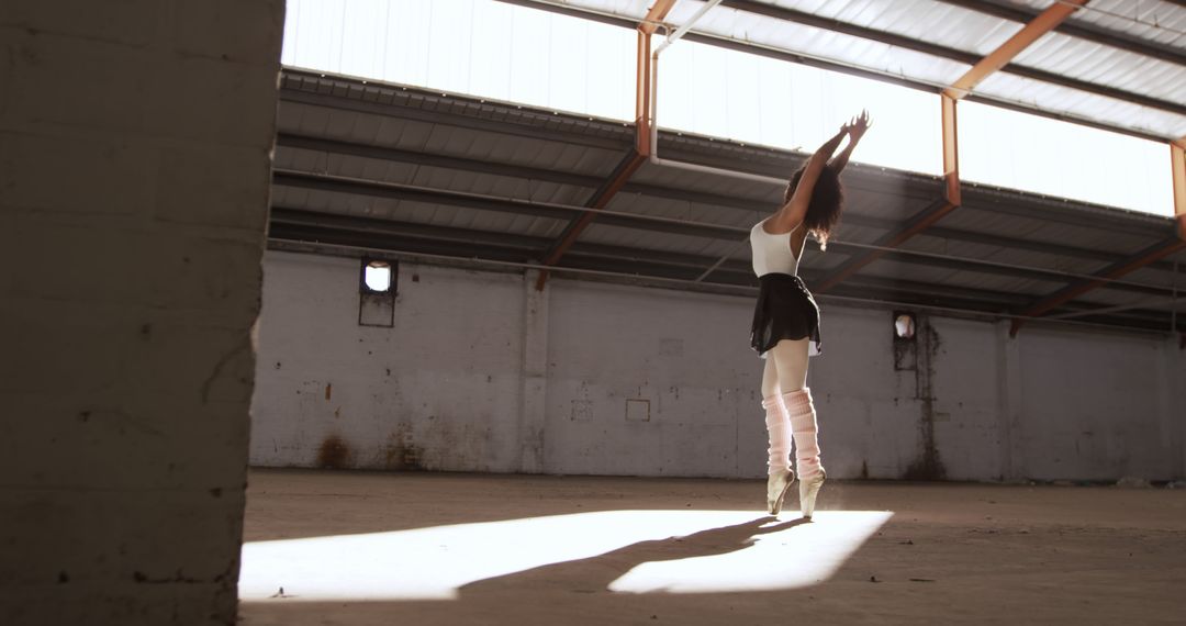 Ballet Dancer Performing in Sunlit Abandoned Warehouse