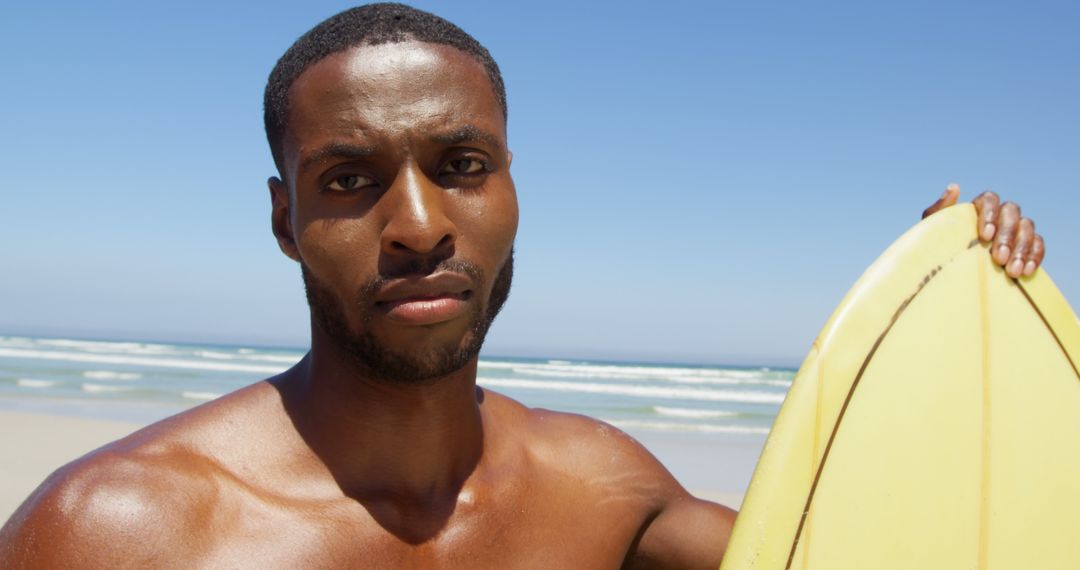 Confident Man Holding Surfboard on Sandy Beach - Free Images, Stock Photos and Pictures on Pikwizard.com