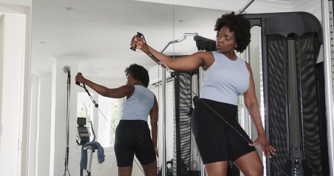 Focused Woman Utilizing Cable Machine in Modern Gym Setting