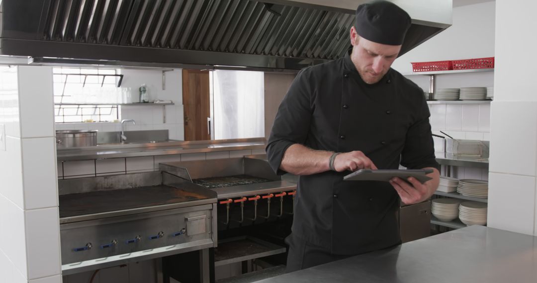 Professional Chef Using Digital Tablet in Commercial Kitchen - Free Images, Stock Photos and Pictures on Pikwizard.com