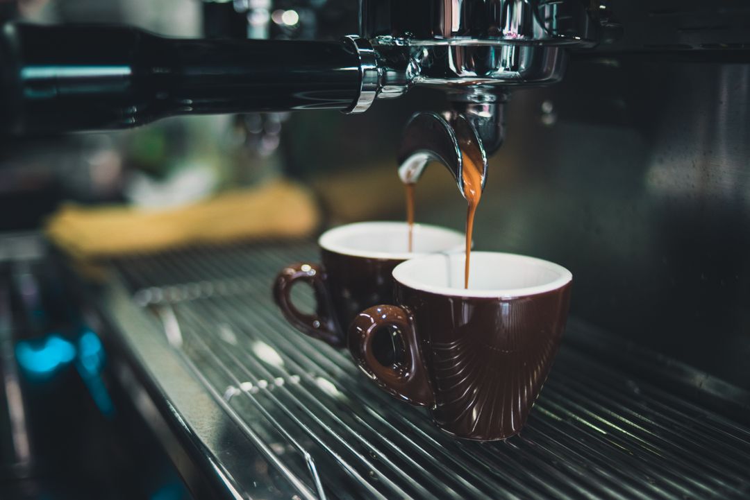 Freshly Brewed Espresso Flowing into Ceramic Cups in Cafe