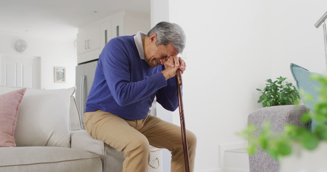 Image of tired, sad senior biracial man sitting and leaning head on walking stick - Free Images, Stock Photos and Pictures on Pikwizard.com