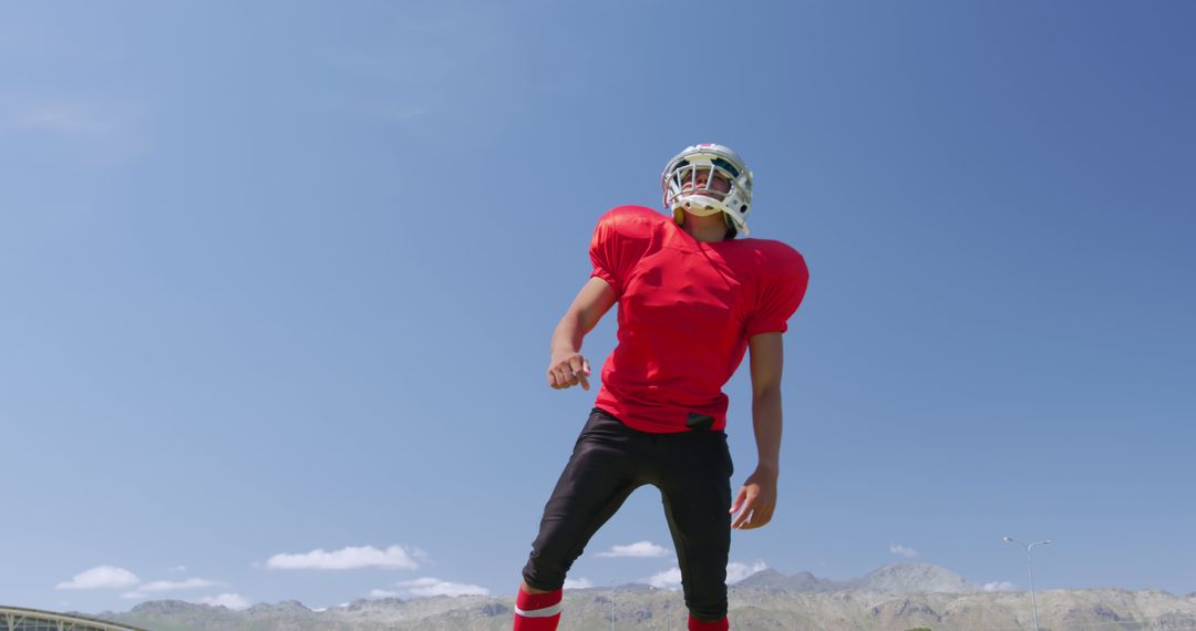 Football Player in Red Uniform and Helmet Standing on Field on Sunny Day - Free Images, Stock Photos and Pictures on Pikwizard.com