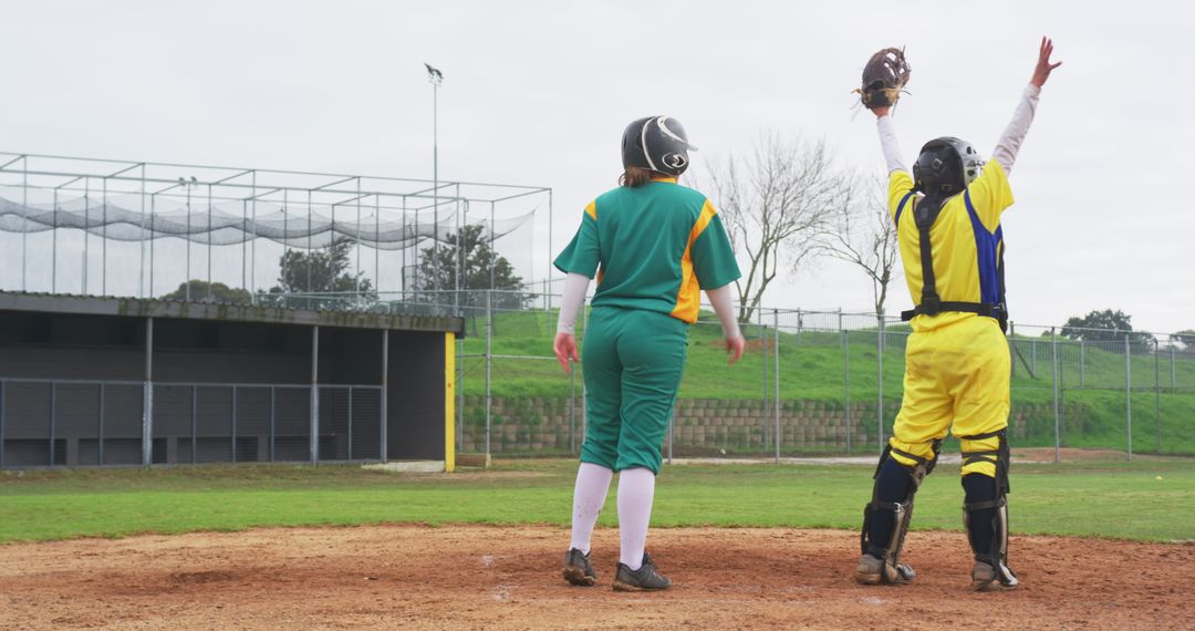 Softball Players on Field in Action with Protective Gear