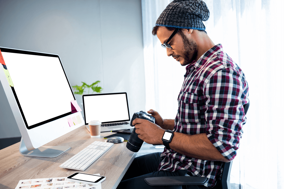 man in beanie reviewing photos in transparent office space - Download Free Stock Images Pikwizard.com