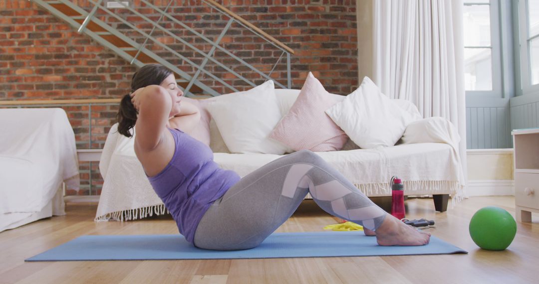 Woman Exercising At Home Doing Sit-Ups On Yoga Mat - Free Images, Stock Photos and Pictures on Pikwizard.com